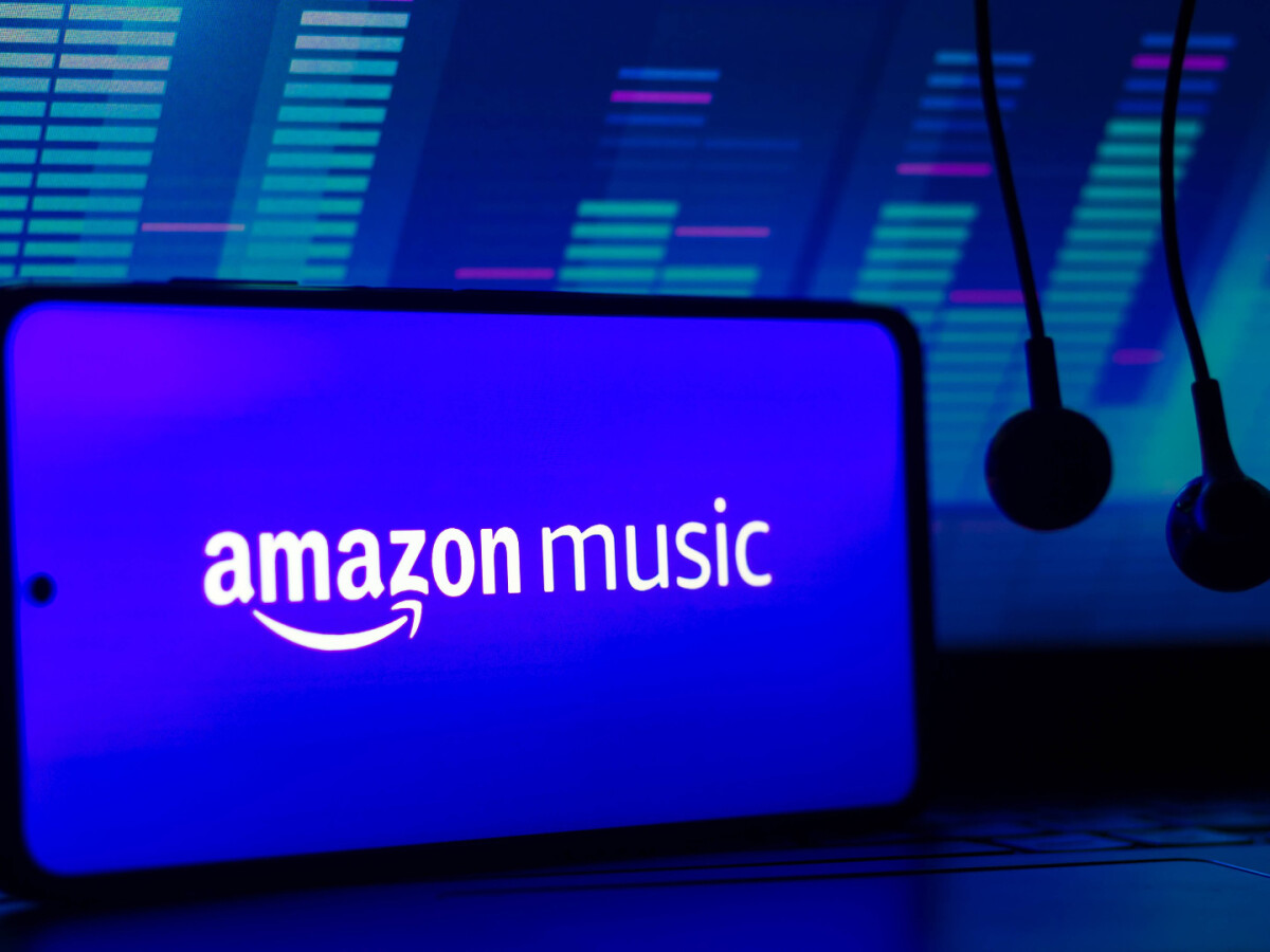 Amazon Music logo on a smartphone with headphones and audio equalizer visuals in the background